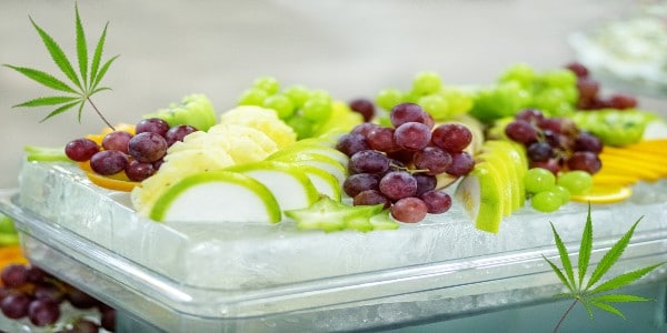 A mix of grapes, apples and oranges with cannabis leaves 