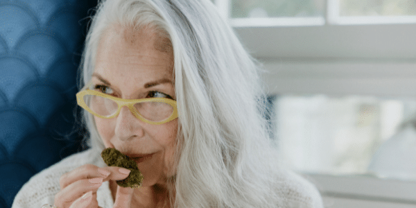 A woman smelling Strawberry Kush strain